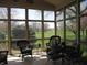 Sunroom with plenty of natural light and wicker furniture looks out over expansive green space at 3504 Inverness Blvd, Carmel, IN 46032