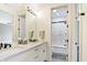 Bright bathroom featuring double vanity with marble countertop and framed mirror, adjacent to walk-in shower at 3582 Pete Dye Blvd, Carmel, IN 46033