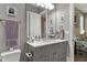 Well-lit bathroom featuring a gray vanity with white marble countertop, framed mirror, and a peek at the main bedroom at 3582 Pete Dye Blvd, Carmel, IN 46033