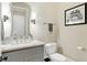 Powder room featuring a white marble countertop, custom mirror, modern lighting, and toilet with a contrasting gray cabinet at 3582 Pete Dye Blvd, Carmel, IN 46033