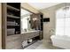 Bathroom featuring wood cabinets, tiled floors, soaking tub, and chandelier at 3582 Pete Dye Blvd, Carmel, IN 46033