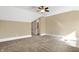 Neutral bedroom with carpet, a ceiling fan, and a doorway leading to a bathroom with white cabinets at 3582 Pete Dye Blvd, Carmel, IN 46033
