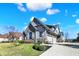 Three car garage home featuring stone and siding, set on a well-kept lawn with established landscaping at 3582 Pete Dye Blvd, Carmel, IN 46033