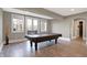 A large pool table sits near the patio access in the finished basement at 3582 Pete Dye Blvd, Carmel, IN 46033