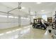 Large garage featuring bright white walls, car, golf cart and multiple overhead doors at 3582 Pete Dye Blvd, Carmel, IN 46033