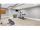 Home gym with neutral colored carpet featuring an elliptical machine, weight bench, and mounted TV at 3582 Pete Dye Blvd, Carmel, IN 46033