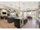 Kitchen with double islands and view of the living room with hardwood floors at 3582 Pete Dye Blvd, Carmel, IN 46033