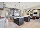 Open-concept kitchen with double islands, gray cabinets, and access to the living area at 3582 Pete Dye Blvd, Carmel, IN 46033