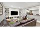 Inviting living room featuring custom built-ins, recessed lighting, and a comfortable brown leather sofa at 3582 Pete Dye Blvd, Carmel, IN 46033