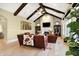 Inviting living room features wood beams, a fireplace, and cozy leather seating with large windows at 3582 Pete Dye Blvd, Carmel, IN 46033