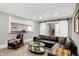 Elegant living room featuring a large leather sofa, modern coffee table, and barn door to the staircase at 3582 Pete Dye Blvd, Carmel, IN 46033