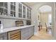 Wet bar with wine refrigerator, gray cabinets, and white countertops at 3582 Pete Dye Blvd, Carmel, IN 46033