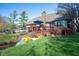Backyard deck with an umbrella, exterior view of home, chimney, lawn, and landscaping create an inviting outdoor space at 4063 Millstream Rd, Greenwood, IN 46143