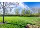 Spacious backyard with lush green grass and mature trees offers ample space for outdoor activities and relaxation at 4063 Millstream Rd, Greenwood, IN 46143