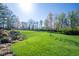 Large grassy backyard with mature trees and landscaped garden area provides a serene and private outdoor space at 4063 Millstream Rd, Greenwood, IN 46143