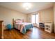 Brightly lit bedroom with hardwood floors, work desk, and a large window with pink curtains at 4063 Millstream Rd, Greenwood, IN 46143