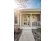 Inviting front porch featuring decorative plants and classic seating, leading to a welcoming front door with glass features at 4063 Millstream Rd, Greenwood, IN 46143