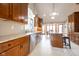 Well-lit kitchen with a stainless steel dishwasher, granite countertops, wood cabinets and an island with seating at 4063 Millstream Rd, Greenwood, IN 46143