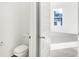 Toilet room featuring a traditional toilet with a white door leading to the bedroom at 4327 Persian St, Greenwood, IN 46143