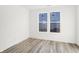 Bedroom featuring wood-look floors, white walls and trim, and a window with backyard views at 4327 Persian St, Greenwood, IN 46143