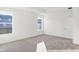 Well-lit bedroom with neutral carpet, two windows providing natural light, and a white door at 4327 Persian St, Greenwood, IN 46143