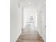 Bright hallway showcasing modern wood-look floors and white walls, leading to sunlit living spaces at 4327 Persian St, Greenwood, IN 46143