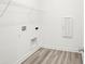 Bright laundry room features wood-look flooring, white walls, and convenient wire shelving for storage at 4327 Persian St, Greenwood, IN 46143