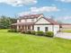 Two-story home featuring a red roof, wraparound porch, and well-maintained lawn with mature landscaping at 4339 W Briarwood Rd, Monrovia, IN 46157