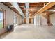 Large unfinished basement featuring exposed ceiling and ductwork, windows, sliding glass door, and painted cement flooring at 4339 W Briarwood Rd, Monrovia, IN 46157