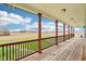 Spacious covered deck with wooden floors, decorative railing, support posts, and an open view of the landscape at 4339 W Briarwood Rd, Monrovia, IN 46157