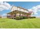 Wide view of home with covered porch, lush lawn, and distant field, showcasing a country-style charm at 4339 W Briarwood Rd, Monrovia, IN 46157