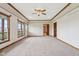 Large living room features wood trim, windows, a ceiling fan, and access to a deck at 4339 W Briarwood Rd, Monrovia, IN 46157