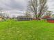 Wide backyard with a large lawn, mature trees, and views of the home's exterior at 4715 Southern Ave, Anderson, IN 46013