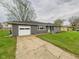 Single-story home with attached garage, concrete driveway and well-maintained lawn with mature trees and landscaping at 4715 Southern Ave, Anderson, IN 46013