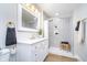 A well-lit bathroom with gold fixtures, white cabinetry, and a modern-designed shower at 4719 Evanston Ave, Indianapolis, IN 46205
