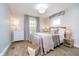 A cozy bedroom featuring hardwood floors, natural light, a bed, and warm decor at 4719 Evanston Ave, Indianapolis, IN 46205