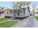 Inviting gray house featuring a cozy front porch, fresh lawn, and a private driveway at 4719 Evanston Ave, Indianapolis, IN 46205