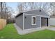 Exterior view of the gray detached garage, with a dark garage door and a manicured lawn at 4719 Evanston Ave, Indianapolis, IN 46205