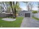 Gray detached garage with a driveway, a seating area in the yard, and fresh landscaping at 4719 Evanston Ave, Indianapolis, IN 46205