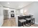 Bright kitchen features stainless steel appliances, white cabinets, and a breakfast bar with seating at 4719 Evanston Ave, Indianapolis, IN 46205