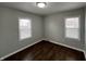 Cozy bedroom with wood-look floors, natural light from two windows, and neutral-colored walls at 4823 Atwell Dr, Lawrence, IN 46226