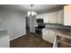 Kitchen boasts white cabinets, stainless steel appliances, and a contemporary lighting fixture at 4823 Atwell Dr, Lawrence, IN 46226