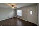 Bright living room with wood-look floors, a ceiling fan, and windows, creating a welcoming atmosphere at 4823 Atwell Dr, Lawrence, IN 46226
