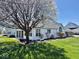 Manicured backyard featuring white siding, blooming trees, and a well-maintained lawn at 5129 W Preakness Ct, Muncie, IN 47304