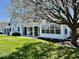 Well-manicured backyard with white siding, lush green lawn, and an enclosed porch at 5129 W Preakness Ct, Muncie, IN 47304