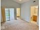 Carpeted bedroom features natural light, access to patio and bathroom at 5129 W Preakness Ct, Muncie, IN 47304