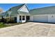 Classic white home with an attached two-car garage, complemented by manicured landscaping at 5129 W Preakness Ct, Muncie, IN 47304