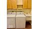 Bright laundry room features a white washer, dryer and utility sink with wood cabinets at 5129 W Preakness Ct, Muncie, IN 47304