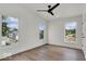 Bright bedroom features three windows, wood flooring, and a modern ceiling fan at 514 Spruce St, Indianapolis, IN 46203