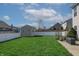 View of the backyard with a green lawn, white fence, and storage shed at 5209 Twin Bridge Blvd, Indianapolis, IN 46239
